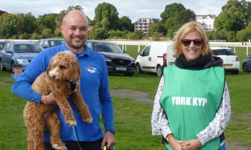 Two Age UK York team members, one holding a dog