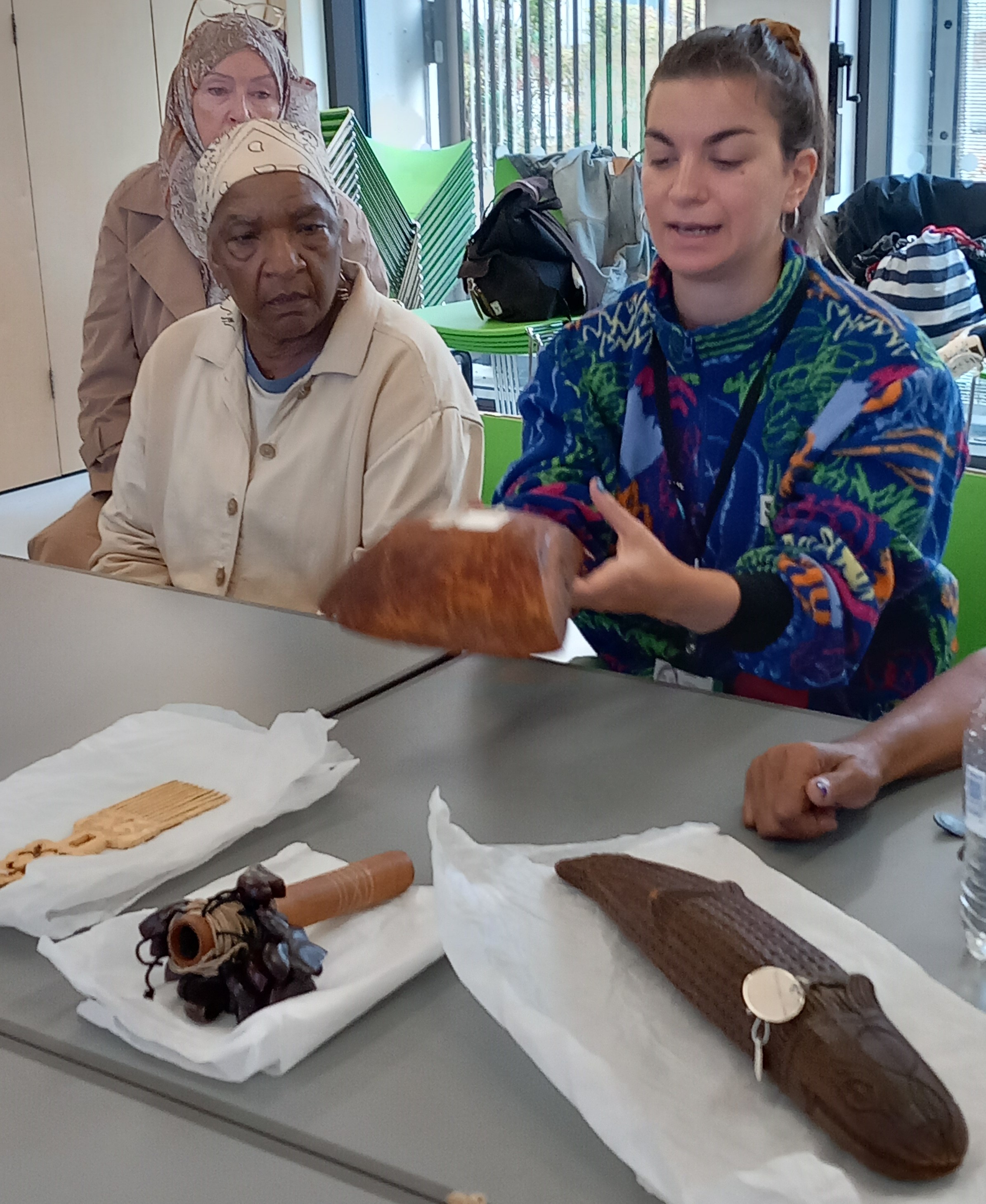 older women looking with interest that a woman is showing to them.