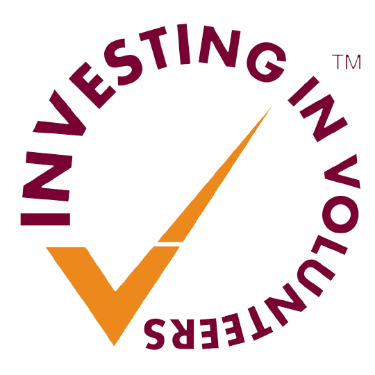 Round Investing in Volunteers logo with maroon text and an orange tick.