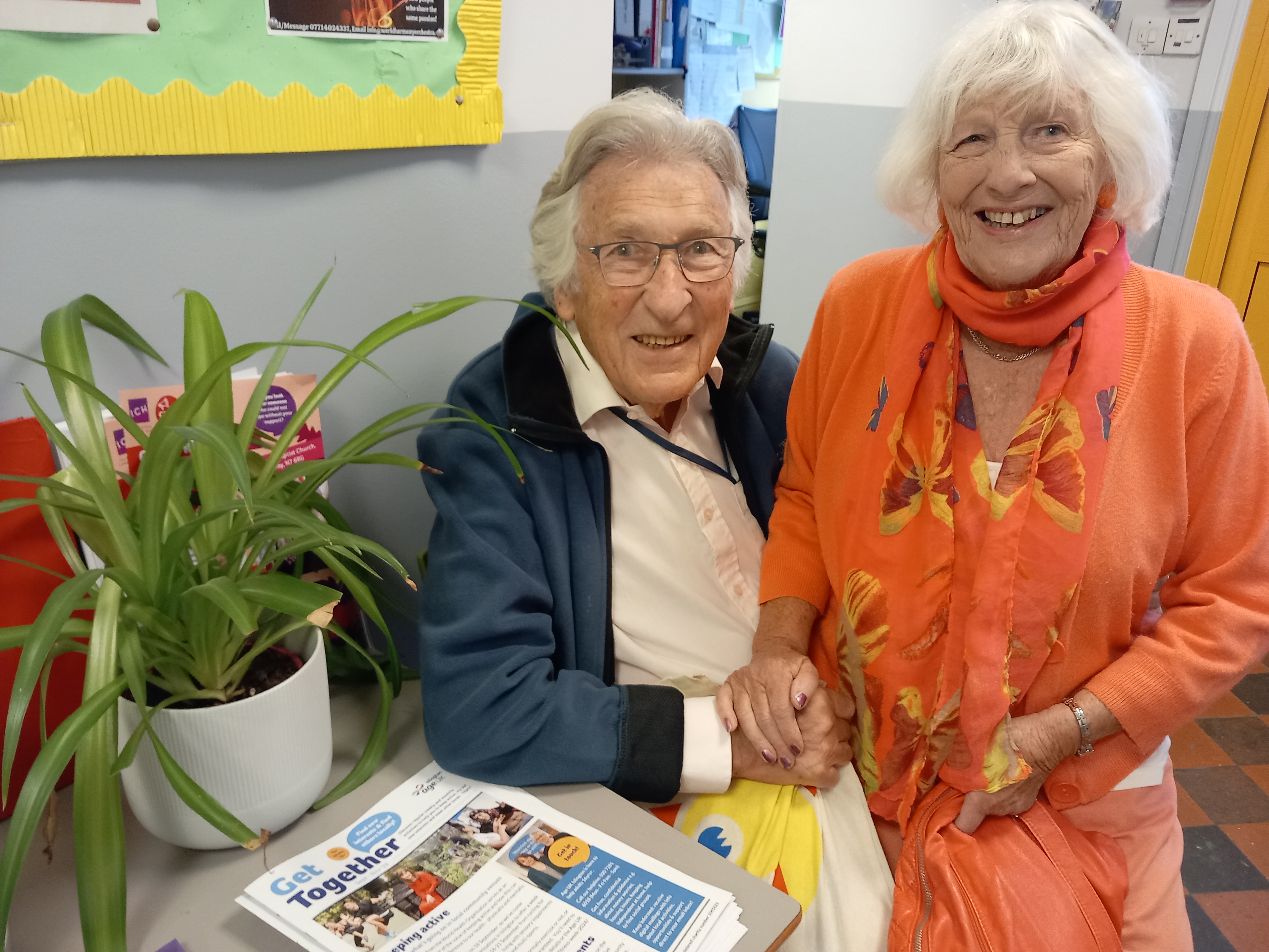 Photo of lady sitting on husband's knee smiling, with plant alongside and Get Together newsletter