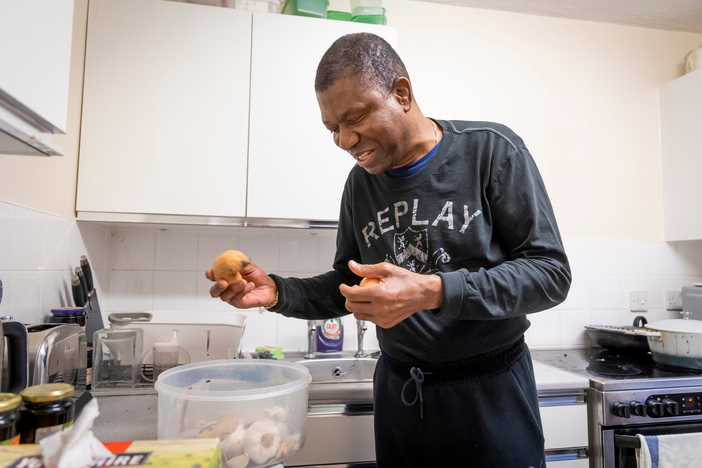 Older man with sensory impairment in kitchen cooking