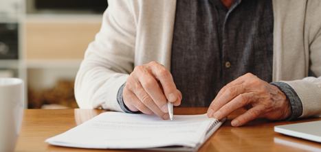 Close up of an older person completing paperwork