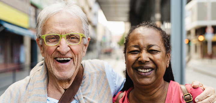 An older man laughing with his carer