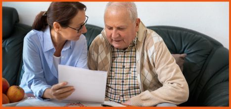 Woman holding a piece of paper to show an older man it's content