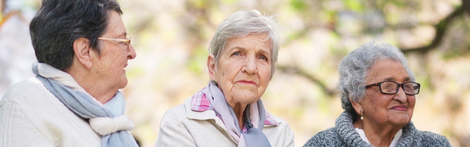 Two older women, looking in different directions into the distance