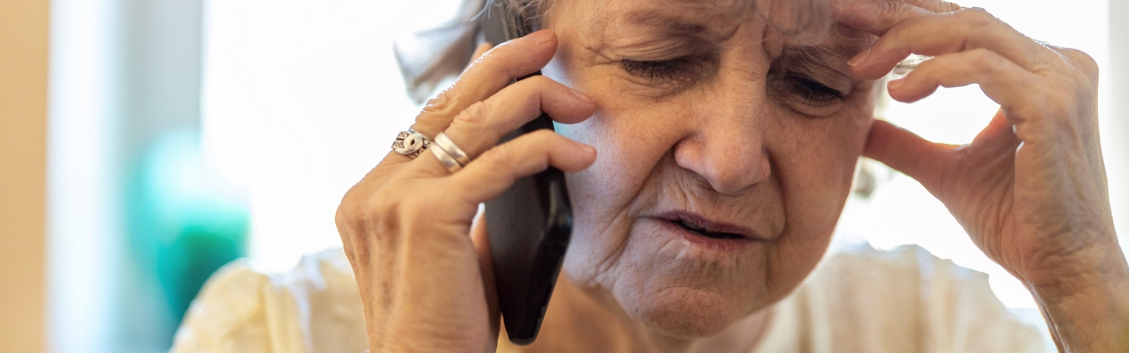 An older woman on the phone, looking distressed