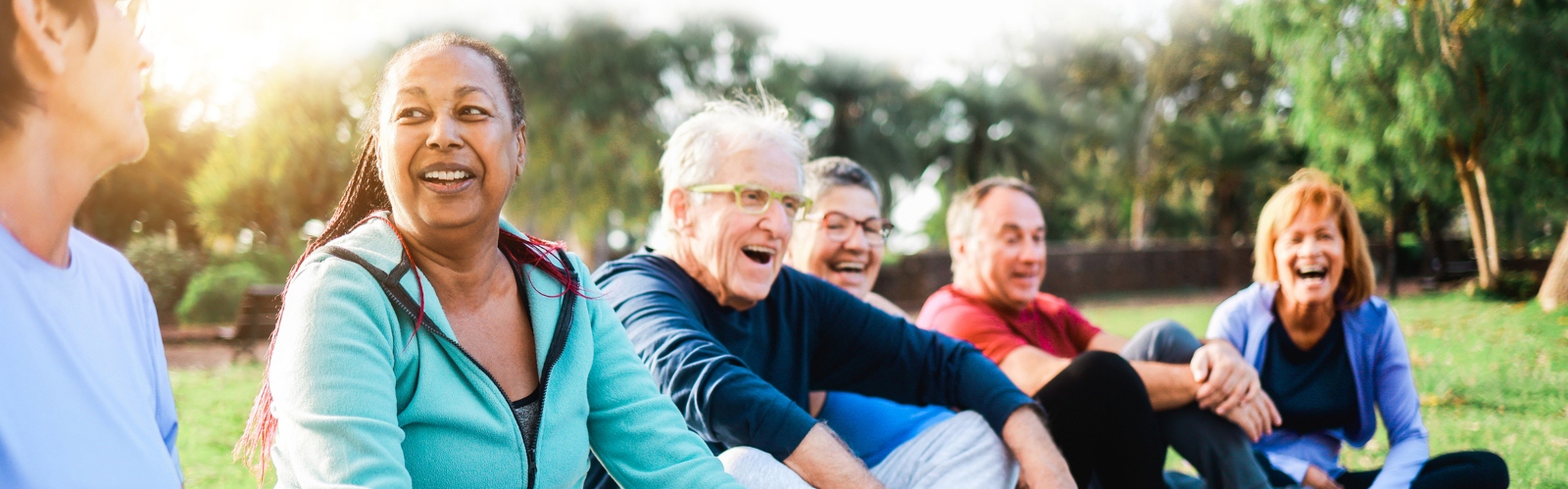 A group of older people sat in a park, laughing