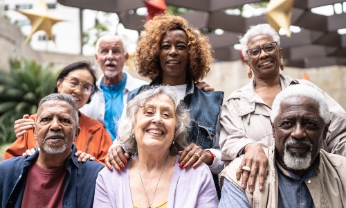 A diverse group of older people, smiling at the camera