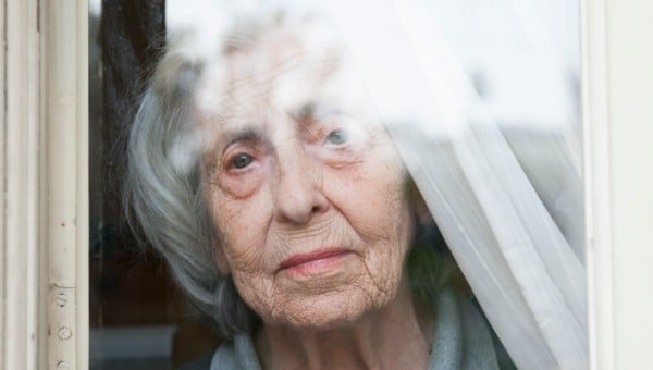 Beryl looks out of her window, her hand pressed against the window pane