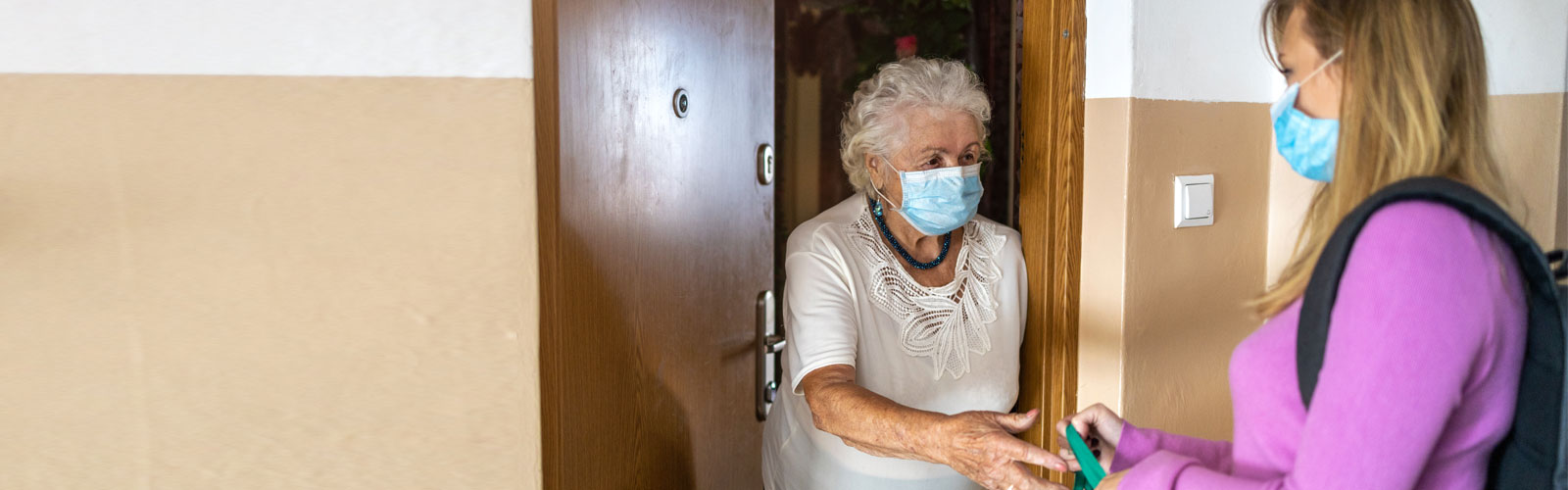 A woman makes a delivery to an older woman in her home