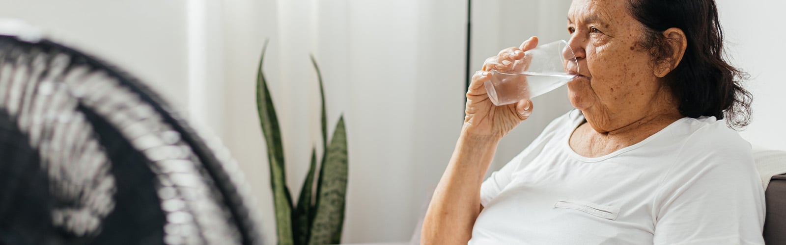 An older woman sat down, drinking a glass of water