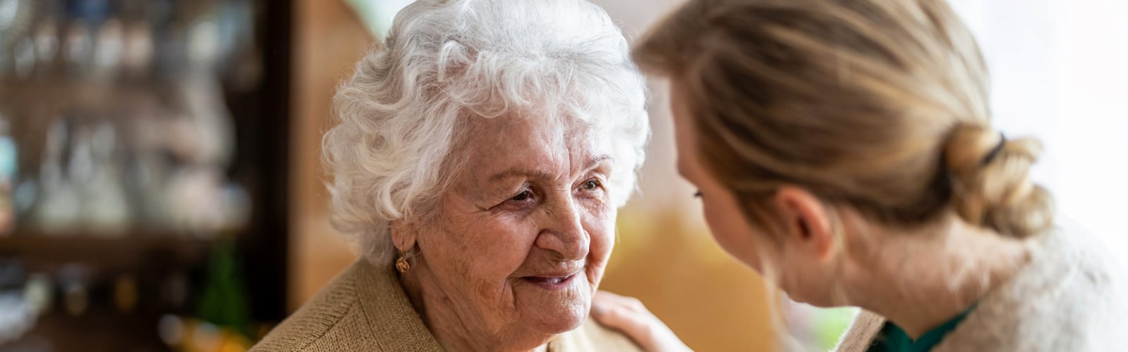 An older woman is reassured by a younger woman