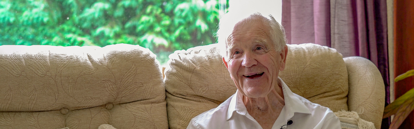 Phil Kingston sitting on his sofa and smiling