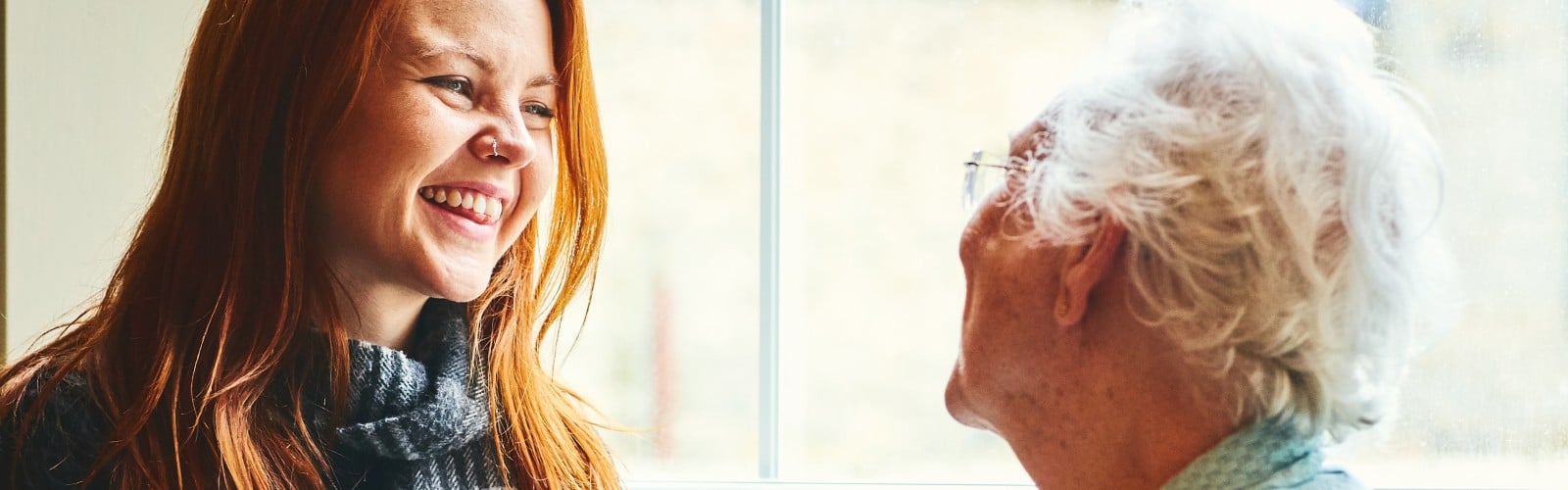 A young woman speaking happily with an older woman