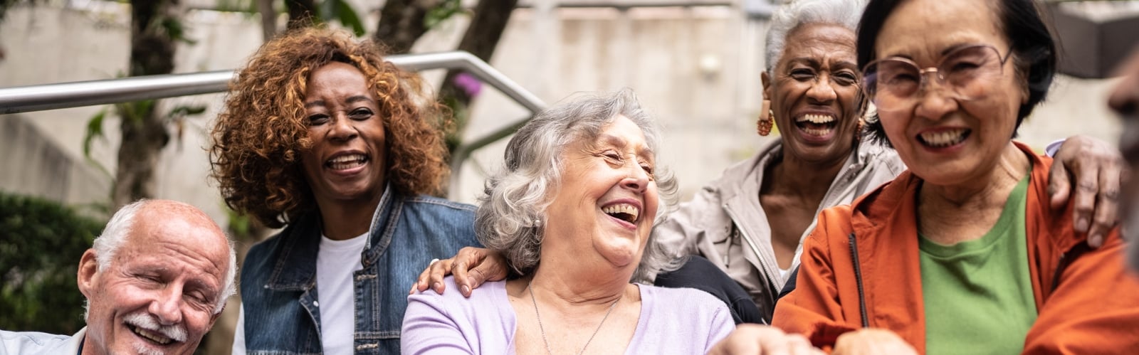 A group of older people of a variety of ethnicities, laughing together