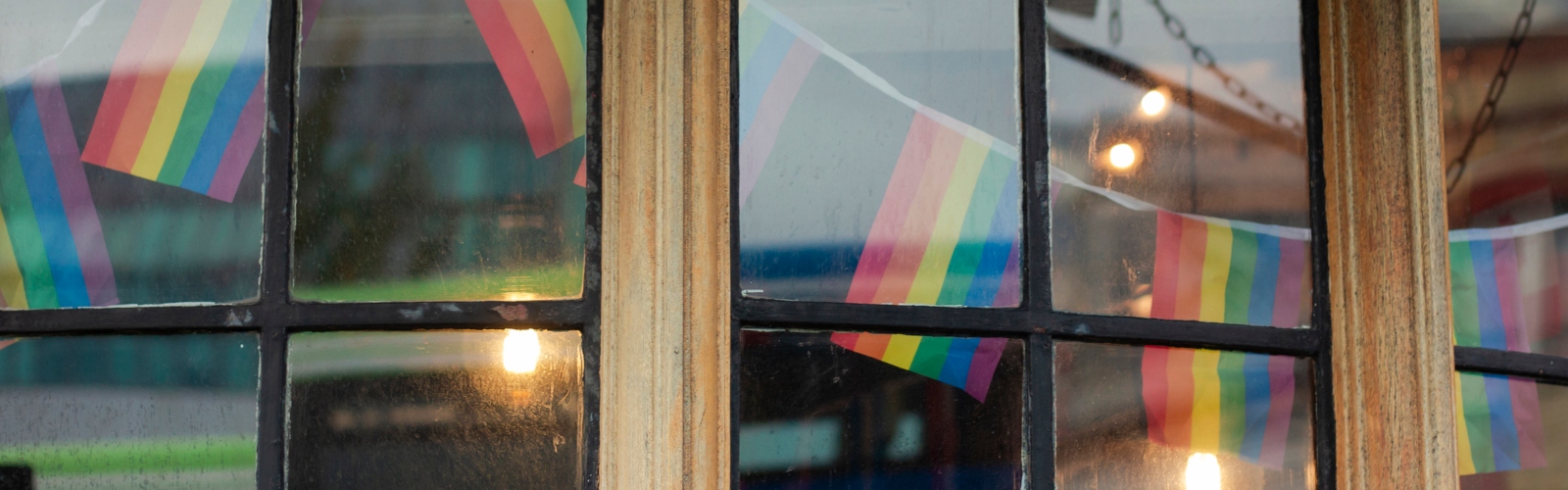 Pride Flag bunting, visible through a cafe window