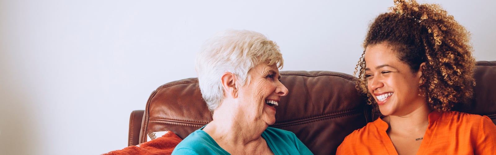 An Age UK volunteer and an older woman talking and smiling