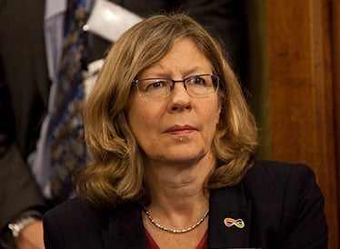 A woman wearing glasses and a black blazer