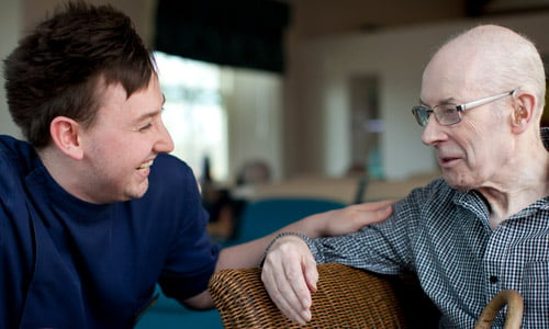 A younger man speaks to an older man