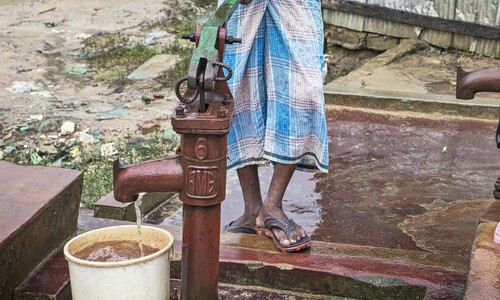 A man pumping water into a bucket