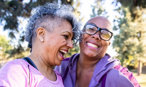 Two women smile and laugh to camera