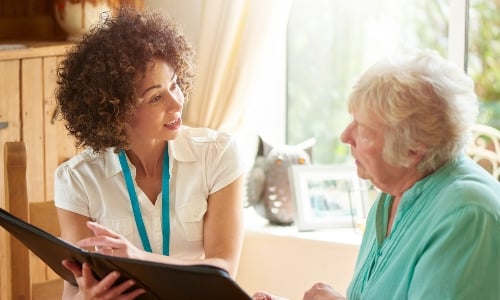 A  young medical professional talks to an older woman