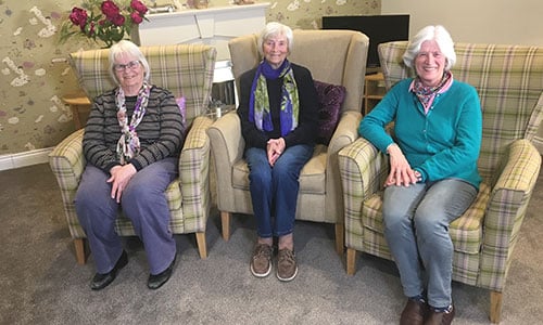 Three ladies sitting on chairs