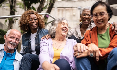 A group of older people of a variety of ethnicities, laughing together