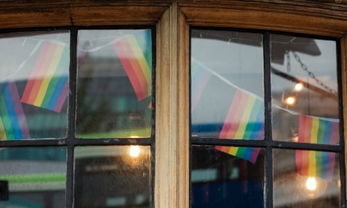 Pride flag bunting, visible through  a cafe window