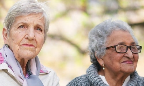 Two older women look thoughtfully into the distance