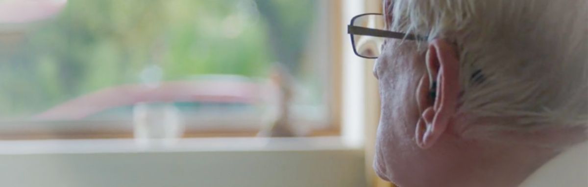 Older man looks out of window