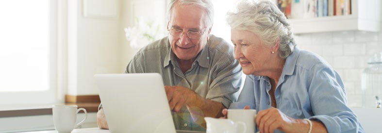 Couple looking at a laptop and smiling